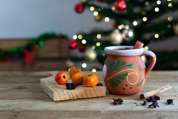 Fototapeta premium Typical Mexican Christmas punch on wooden table with Christmas tree in the background.