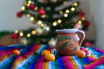 Typical Mexican Christmas punch on colorful serape with Christmas tree in the background.