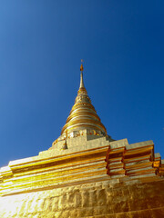 Fototapeta premium Beautiful temples in Thailand. Awesome view of the golden stupa at Wat Pavaranivesh Vihara Ratchawaraihan in Bangkok, Thailand. The amazing chedi of the Buddhist temple.