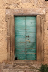 Aged Green Wooden Door with Stone Frame in Rural Village, Italy