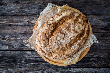 Loaf of homemade, fresh baked cottage bread on wooden table
