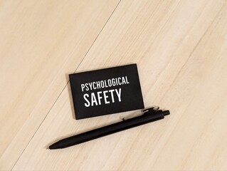 a black pen and sticky note with the words Psychological Safety. Psychological concept