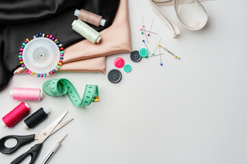 Crafting essentials for sewing projects displayed on a table with fabric, threads, and tools