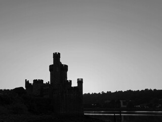 Fototapeta premium Blackrock castle observatory silhouette in the rays of sunset sun black and white monochrome background