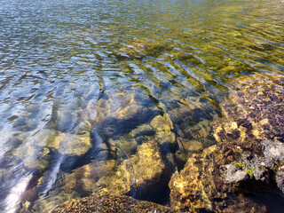 Mountain lake relaxation, pure waterscape natural background. Laying somewhere in the mountains