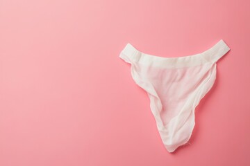 Delicate white thong on a soft pink background highlighting intimate apparel design and color contrast in a minimalist setting