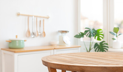Round kitchen table in front of blurred kitchenware, furniture and window interior background