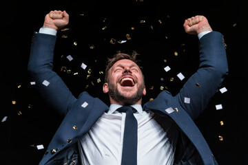 Happy businessman, fist pump and confetti in celebration, winning or achievement against a studio background.