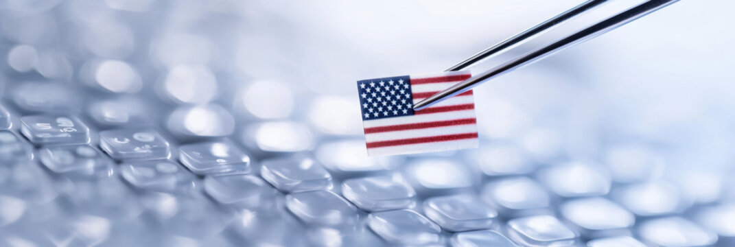 Small American flag held by medical tweezers on blurred biomedical background