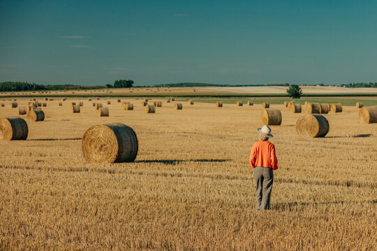 Woman in orange sweater walking on agricultural field