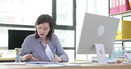 Woman working on computer and documents in office