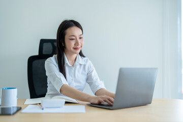 Young asian businesswoman working on laptop in modern office