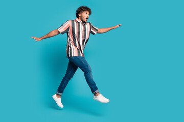 Full size photo of nice young man jump empty space wear shirt isolated on teal color background