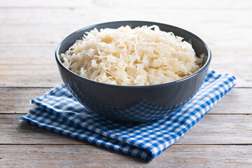 Sauerkraut in a bowl on wooden table.