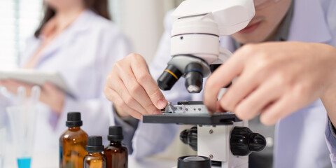 Scientist Conducting Microbial Analysis with Microscope for Research