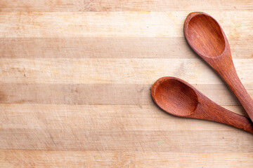 2 wooden spoons on a chopping board  top down picture