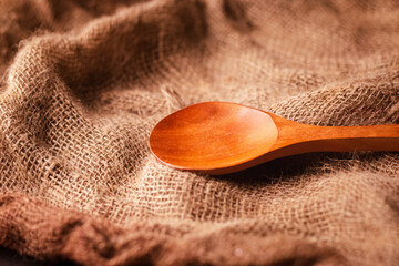 isolated wooden spoon on a brown cloth background