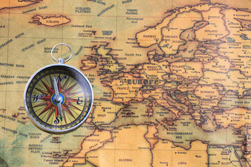 Classic round compass on background of old vintage map of world