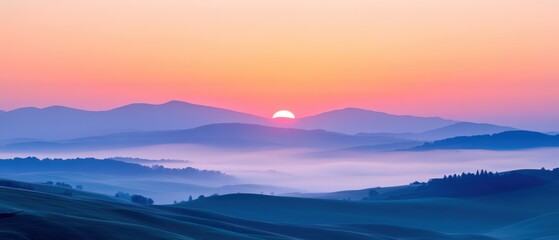 Fototapeta premium Breathtaking sunrise over rolling hills, enveloped in mist, showcasing vibrant colors and serene beauty.