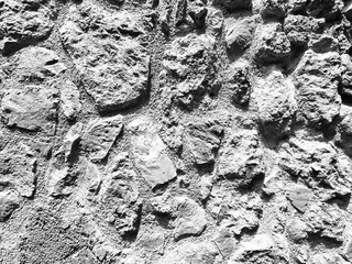 evocative black and white image texture of ancient wall of large stones in southern Italy
