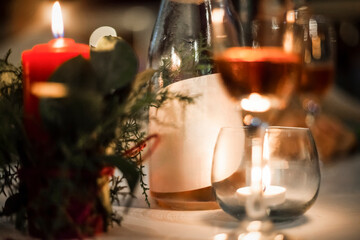 Christmas dinner table setting with candlelight, wine, and festive decorations