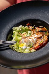 A refreshing dish of grilled peaches paired with diced cucumber and creamy burrata. This vibrant combination of sweet, savory, and fresh ingredients creates a perfect summer dish.