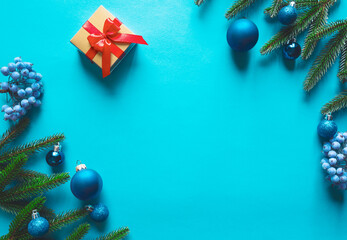 Christmas card concept with fir tree branches, presents, snowflakes, decorations on blue background.