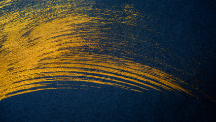Golden traces of an artistic brush on a black background.