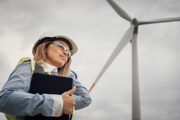 A skilled and professional female engineer is expertly overseeing a significant wind turbine project that focuses on promoting sustainability and harnessing renewable energy sources for the future