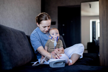 Woman with infant son makes inhalations using a nebulizer at home