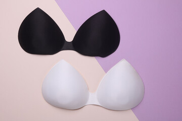 Women's invisible bras on pastel background. Top view