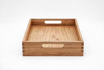 Solid oak wood tray with dovetail joints and cutout handles on the sides for easy carrying on white background