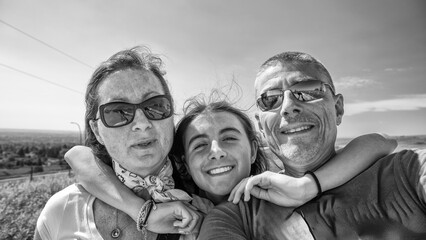 Happy family of three people take selfie outdoor