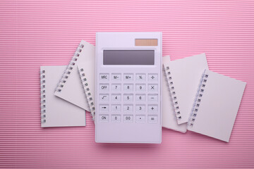 Group of Blank white spiral notebooks with calculator on pink background