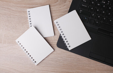 Laptop and white blank spiral notebooks on table. Education, business concept. Top view