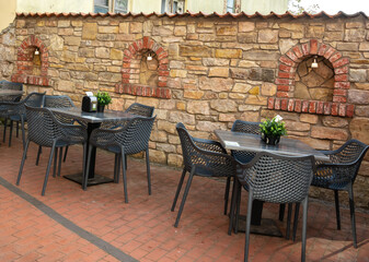 chairs and small tables in a street outdoors cafe in the town Cesis,Latvia.
