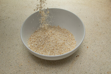 Pour dry wheat flour into a bowl white, oats, dry, breakfast, cereal,cereal
