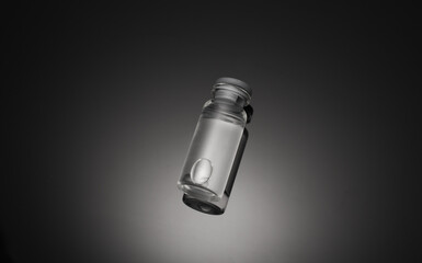 Medical glass vial with liquid on a black background