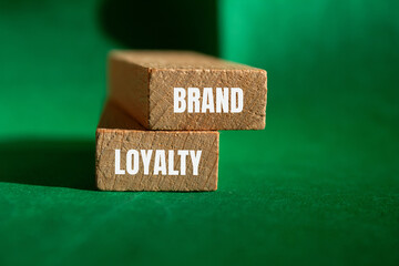 Brand loyalty message written on wooden blocks with green background. Conceptual brand loyalty symbol. Copy space.