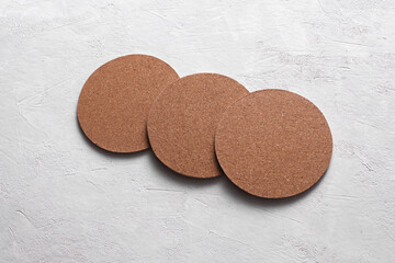 Cork coasters for drinks on white concrete background