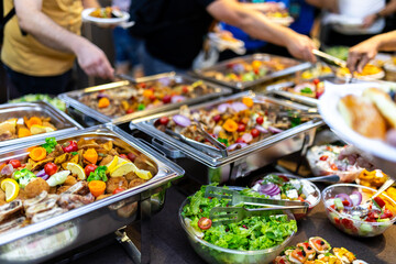 Buffet-style feast featuring diverse dishes and fresh salads at a lively community gathering in the evening