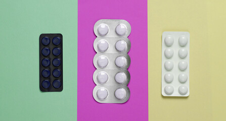 Different blisters of pills on colored backgrounds. Top view. Medicine minimal layout