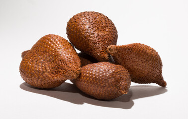Salak (Salacca zalacca) is a species of palm tree (family Arecaceae), snake fruit or snakeskin fruit due. Several fruits on a white background.
