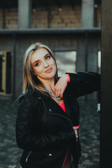 Fototapeta premium A woman in a black jacket and red shirt poses for a picture