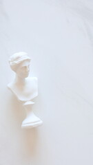 Marble head of young woman on marble background, copy space