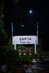 A sign with the word khun tan on it is lit up at night