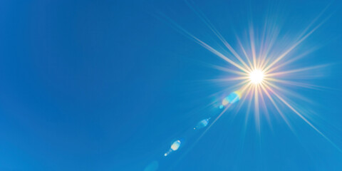 Obraz premium Bright sunburst with lens flares on the clean blue sky, abstract nature photo