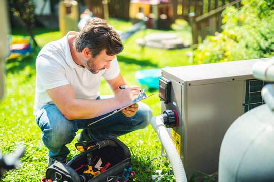 Electrician working on heat pump close to a pool