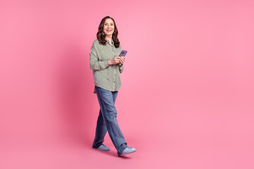 Full body portrait of pretty aged lady walk empty space wear shirt isolated on pink color background