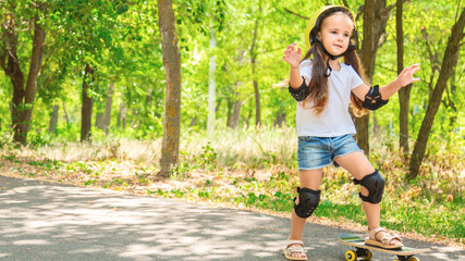 Girl skateboard with safety equipment - helmet, knee and elbow pads. Safe summer activity. Kids activity.
